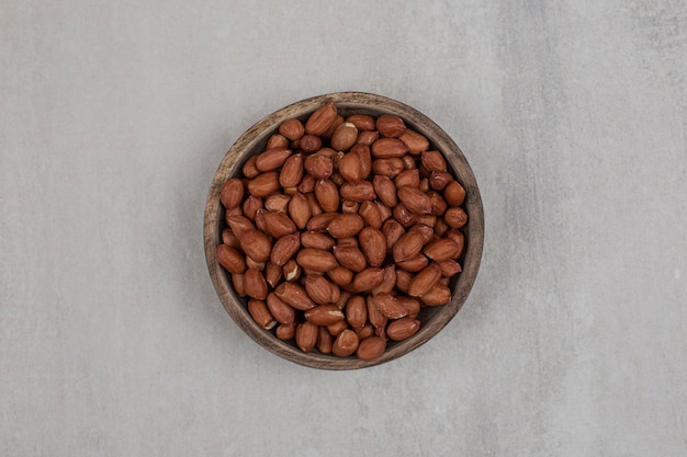 Heap of fresh peanuts in wooden bowl.