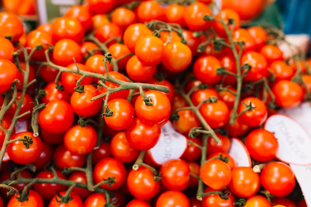 Free photo heap of red cherry tomatoes with green twig