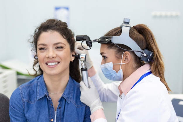 Free photo hearing exam otolaryngologist doctor checking woman's ear using otoscope or auriscope at medical clinic