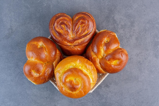 Heart buns piled on a small basket on marble background. High quality photo