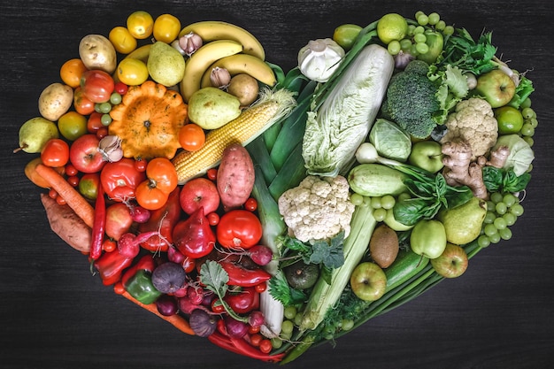 Free photo heart made of fresh vegetables and fruit on wooden background