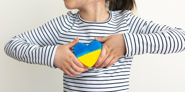 Heart painted in the colors of the flag of ukraine in childrens hands