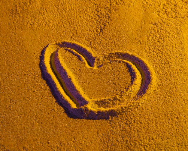 Free photo heart shape drawn on sand texture