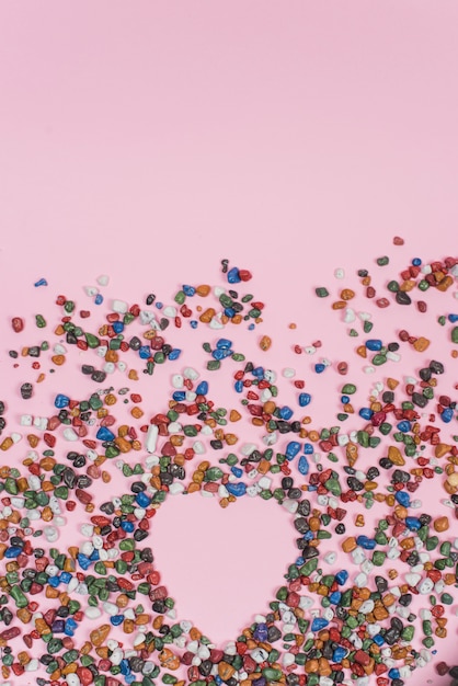 Free Photo heart shape from small stones on pink table