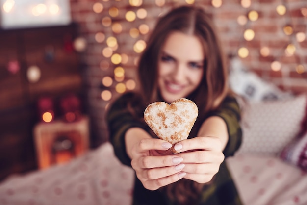 Free photo heart-shaped cookie in human hand