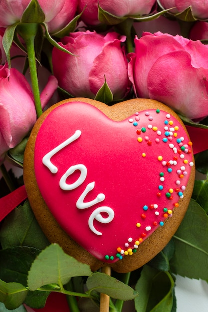 Heart-shaped cookie on rose bouquet