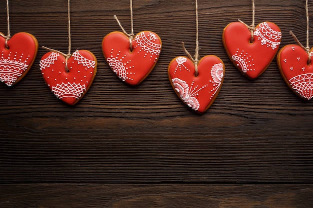 Free photo heart-shaped cookies hanging from ropes