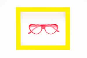 Free photo heart-shaped glasses inside frame