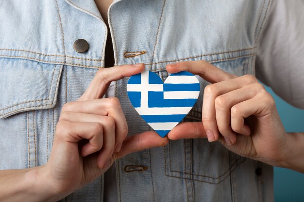 Heart shaped greece flag held in hands