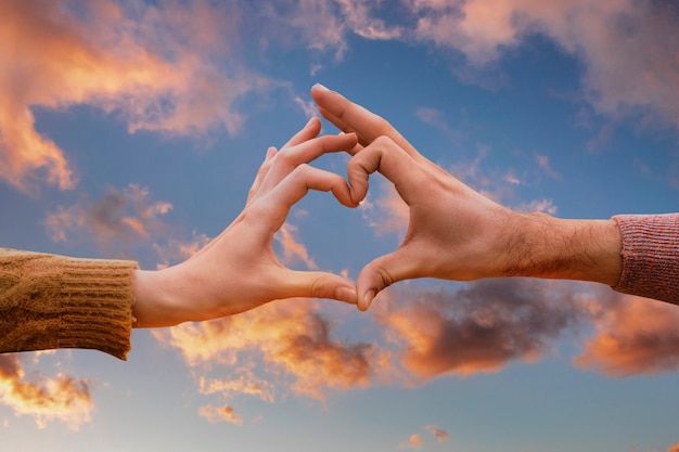 Free photo heart-shaped hands on a sunset