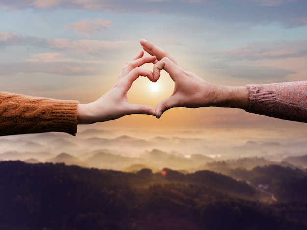 Free photo heart-shaped hands on a sunset