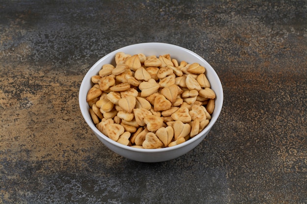 Heart shaped salty crackers in white bowl.