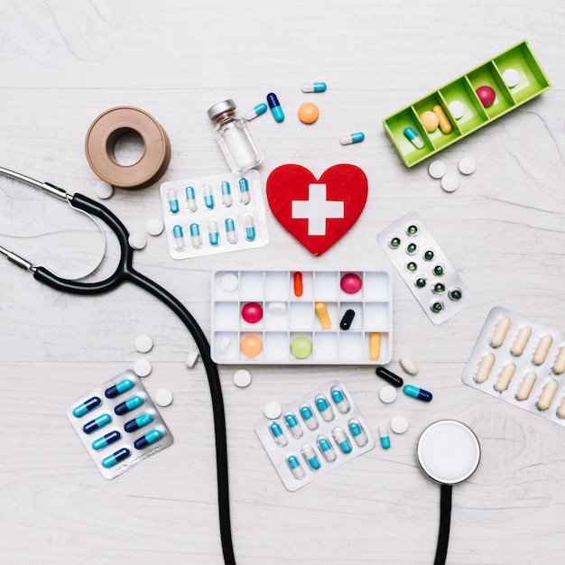 Heart with cross near stethoscope and medications