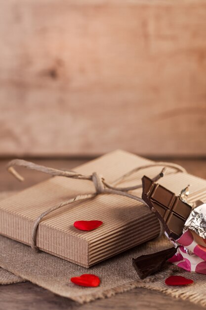 Hearts,chocolate and valentine's gift on wooden background