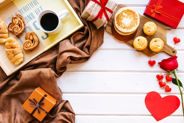 Hearts and rose near presents and breakfast