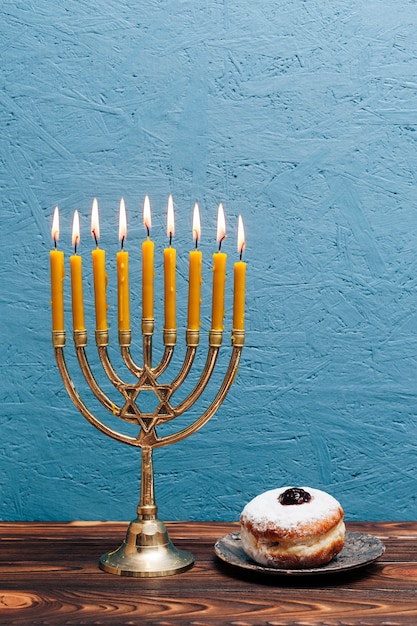 Free Photo hebrew menorah with delicious donut