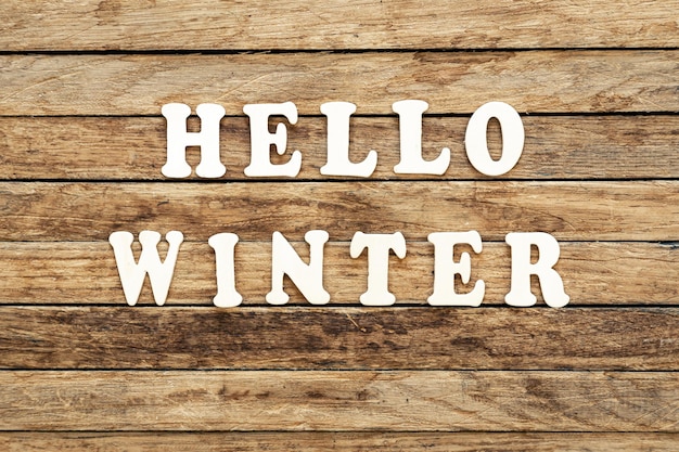 Free photo hello winter word written on wood letters text on wooden table for your design top view concept