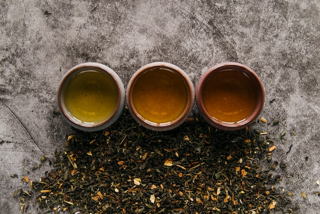 Free photo herbal chinese teacup with dried tea herb on concrete backdrop