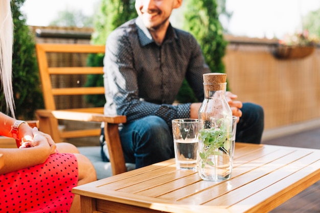 Herbal drink on wooden table with couple sitting on chair