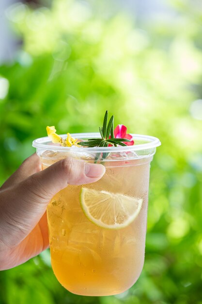 Herbal Iced Tea Cocktail with Edible Flowers on wooden surface