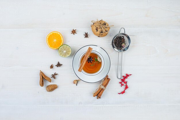 Herbal tea and cookies with tea strainer,herbs,citrus fruits