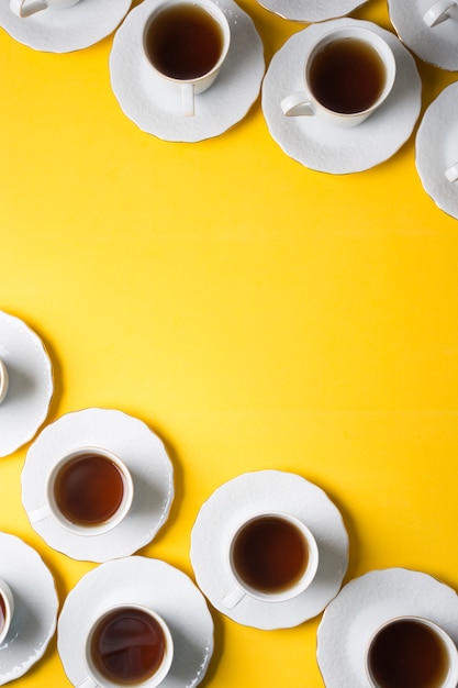 Free photo herbal tea cup and saucers on the corner of the yellow background