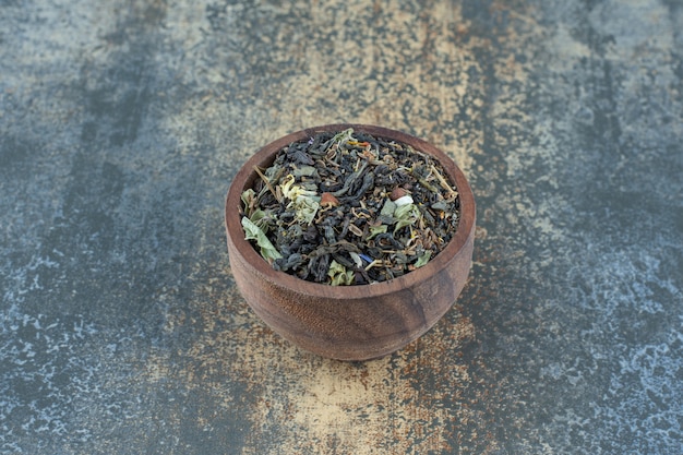 Herbal tea leaves in wooden bowl.