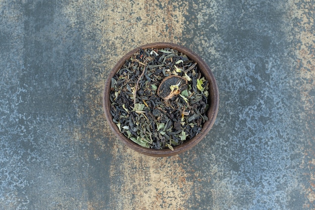 Herbal tea leaves in wooden bowl.