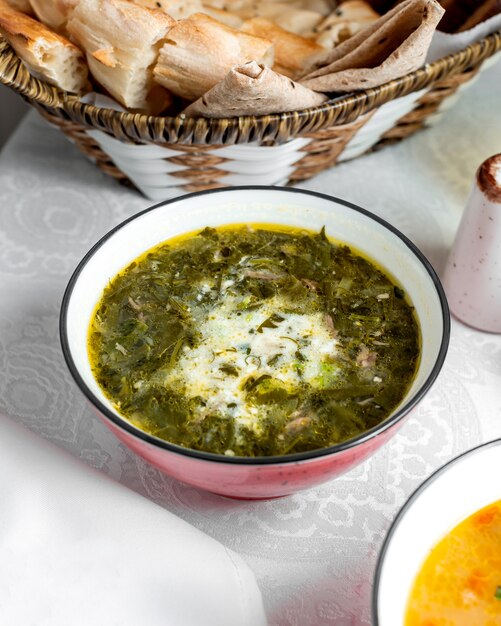 Herbs soup bowl garnished with yogurt