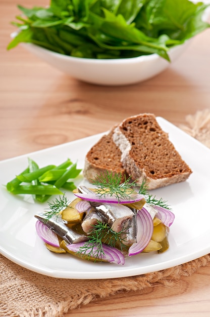 Free Photo herring salad with pickled cucumbers and onions