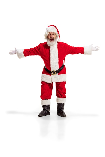 Free photo hey, hello. holly jolly x mas festive noel. full length of funny happy santa in headwear, costume, black belt, white gloves, waves with arm palm standing at studio over white background