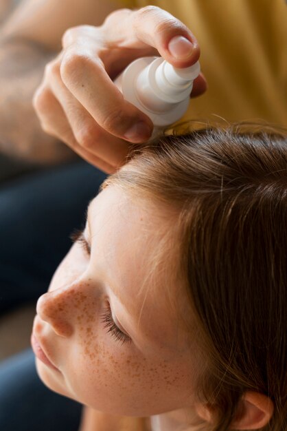 High angle adult applying lice treatment