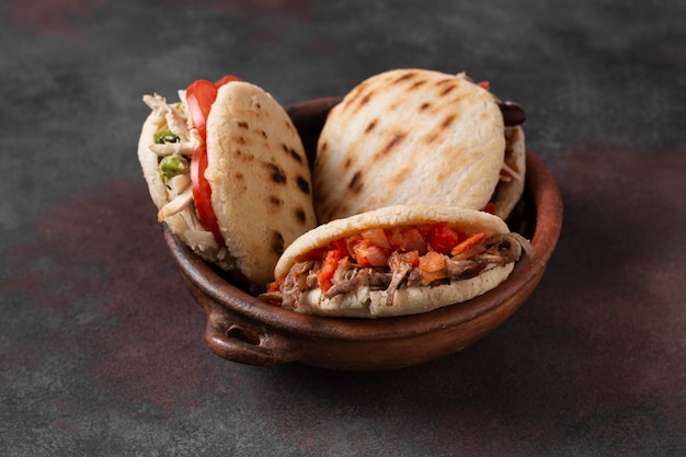 Free photo high angle arepas with meat and tomatoes