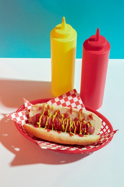 Free photo high angle arrangement with hot dog and sauce bottles