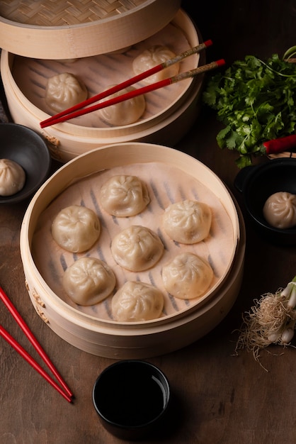 Free photo high angle of asian dumplings with chopsticks and herbs