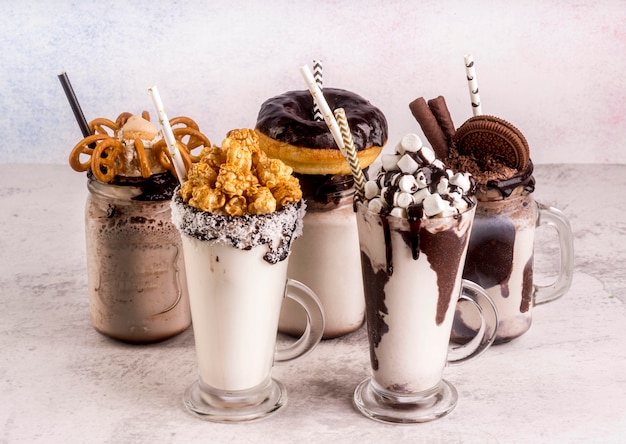 Free photo high angle of assortment of desserts with straws and chocolate