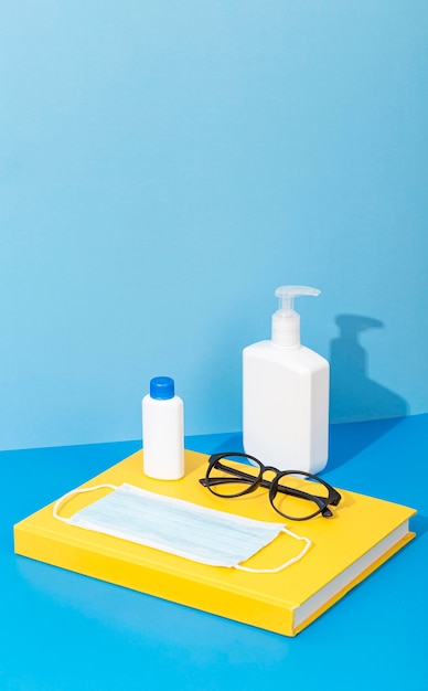 High angle of back to school supplies with book and hand sanitizer