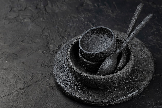 Free photo high angle of black bowls and spoons on slate