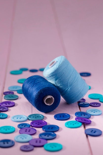 Free photo high angle of blue buttons and thread reels