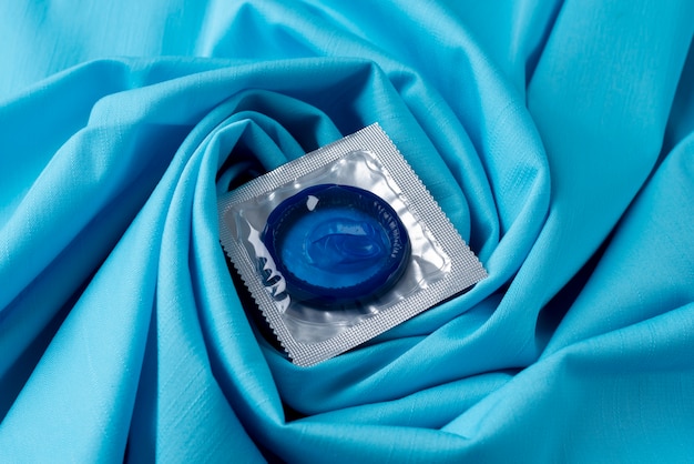 Free Photo high angle blue condom on sheet