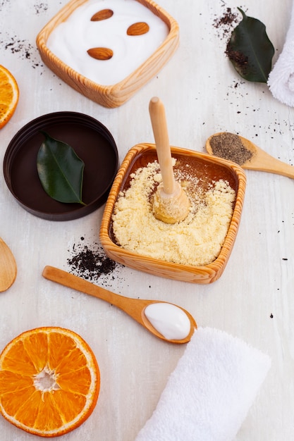 High angle of body butter and orange slice on plain background