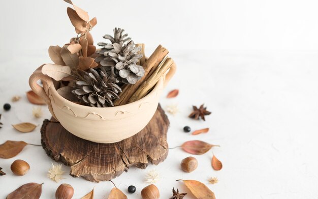 High angle of bowl with autumn leaves and pine cones