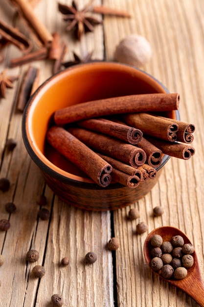 Free Photo high angle of bowl with cinnamon sticks and nutmeg