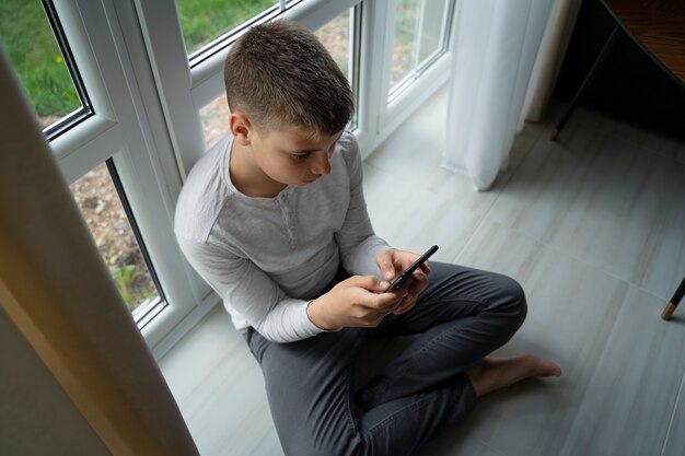 High angle boy holding smartphone