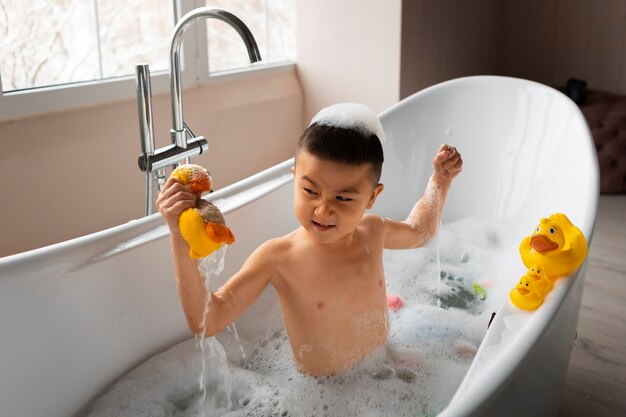 High angle boy playing in bathtub