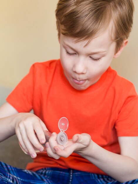 High angle boy using hand sanitizer