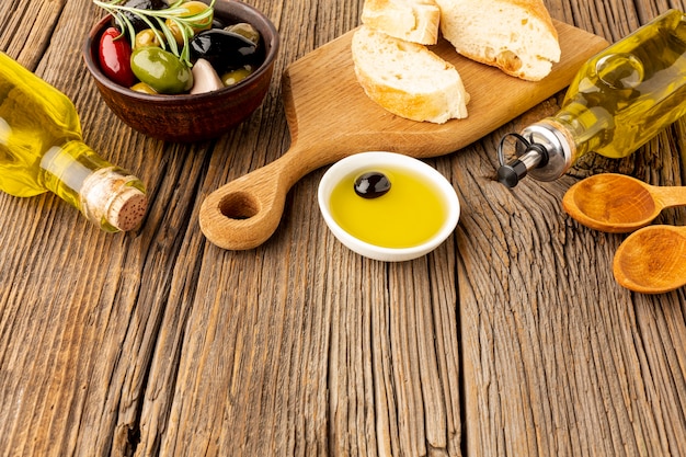 Free photo high angle bread olives mix and oil bottles