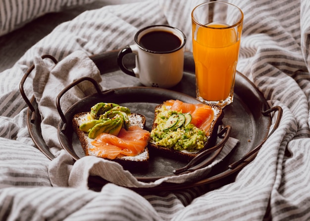 Free photo high angle of breakfast sandwiches on bed with avocado and salmon