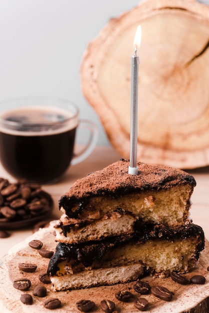 Free photo high angle of cake slice with candle and coffee