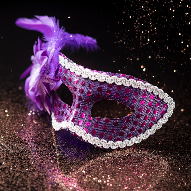 High angle of carnival mask with glitter and feathers